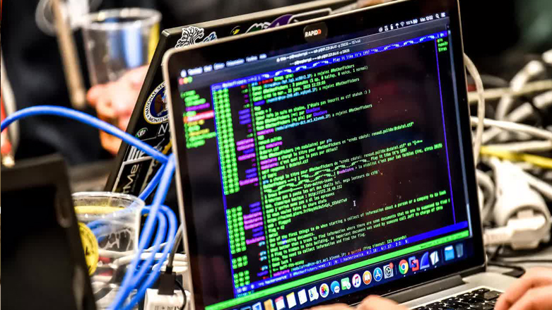A person delivers a computer payload while working on a laptop, Jan. 22, 2019 in Lille, during the 11th International Cybersecurity Forum. (Photo: Philippe Huguen / AFP)