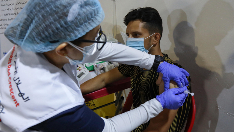 A health worker with the Emirati Red Crescent gives a shot of the Covid-19 vaccine at a centre for Iraqis displaced by conflict, in the Debaga camp east of Kurdish capital Erbil, May 25, 2021. (Photo: Safin Hamed / AFP)