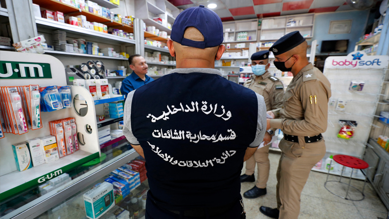 A member of Iraq's Interior Ministry's anti-"fake news" team speaks to a pharmacist in the capital Baghdad, as part of a campaign to spread awareness among the population on fake news, May 20, 2021. (Photo: Ahmad Al-Rubaye / AFP)