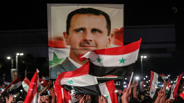 Syrians wave national flags and carry a large portrait of their president as they celebrate in the streets of the capital Damascus, May 27, 2021. (Photo: Louai Beshara/AFP)