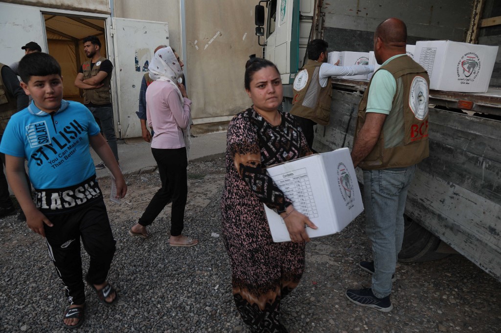 Displaced Yazidis receive food aid at the Chamishko camp for internally displaced persons (IDP) in the city of Zakho in the north of Iraq's autonomous Kurdish region on May 5, 2022. (Photo: Safin Hamed/AFP)