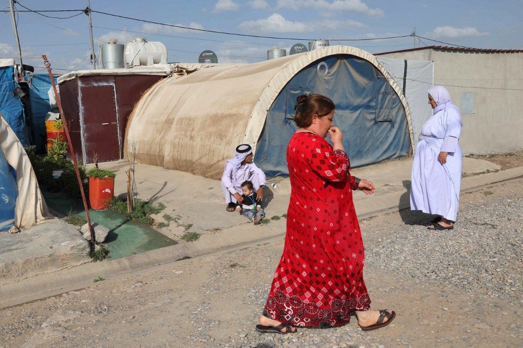 Displaced Yazidis stand near their tent at the Chamishko camp for internally displaced persons (IDP) in the city of Zakho in the north of Iraq's autonomous Kurdish region on May 5, 2022. (Photo: Safin Hamed/AFP)