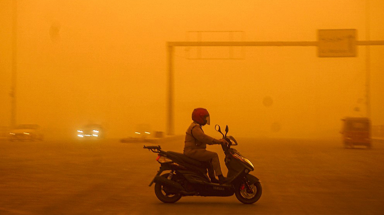 A motorist drives a scooter through as a heavy dust storm hits Iraq's capital Baghdad, May 16, 2022. (Photo: Sabah Arar/AFP)