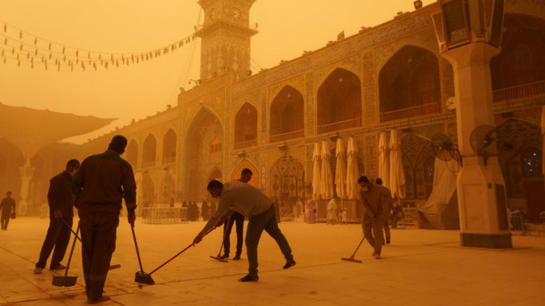 Volunteers clean up at the Imam Ali shrine during a sandstorm in Iraq's holy city of Najaf, May 16, 2022. (Photo: Qassem Al-Kaabi/AFP)