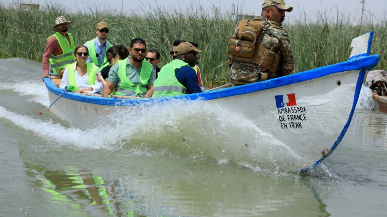 أعضاء في بعثة فرنسية خلال جولة على قارب في مياه أهوار العراق في محافظة ذي قار جنوب البلاد في 19 أيار/مايو 2022 في إطار حملة تنظيف بتمويل من السفارة الفرنسية في بغداد - الصورة لفرانس 24