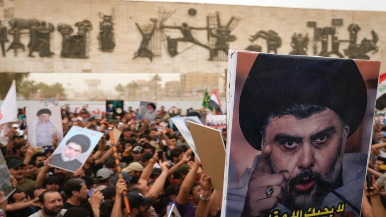 Followers of Shiite cleric Muqtada al-Sadr hold posters with his photo as they celebrate the passing of a law criminalizing the normalization of ties with Israel, in Tahrir Square, Baghdad, Iraq, May 26, 2022. (Photo: Hadi Mizban/AP)