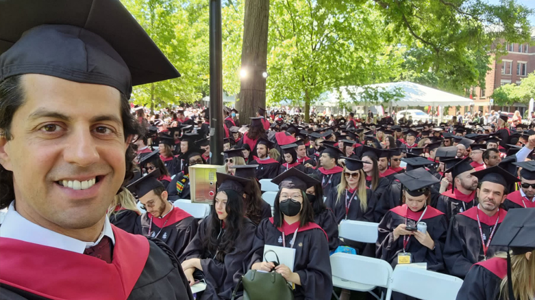 Alan Aqrawi, 45, takes a selfie with his fellow graduates in the background, May 29, 2022. (Photo: Courtesy of Peri-Khan Aqrawi)