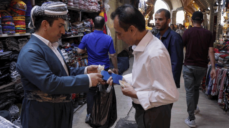 In this picture taken on April 30, 2023, a man makes a purchase from a vendor near the citadel of Erbil, the capital of the autonomous Kurdistan region (Photo: SAFIN HAMID/AFP).