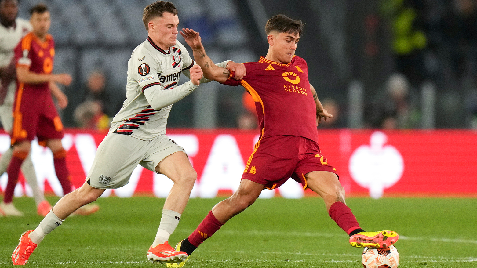 Roma's Paulo Dybala, right, challenges for the ball with Leverkusen's Florian Wirtz during the Europa League semifinal first leg. (Photo: AP)