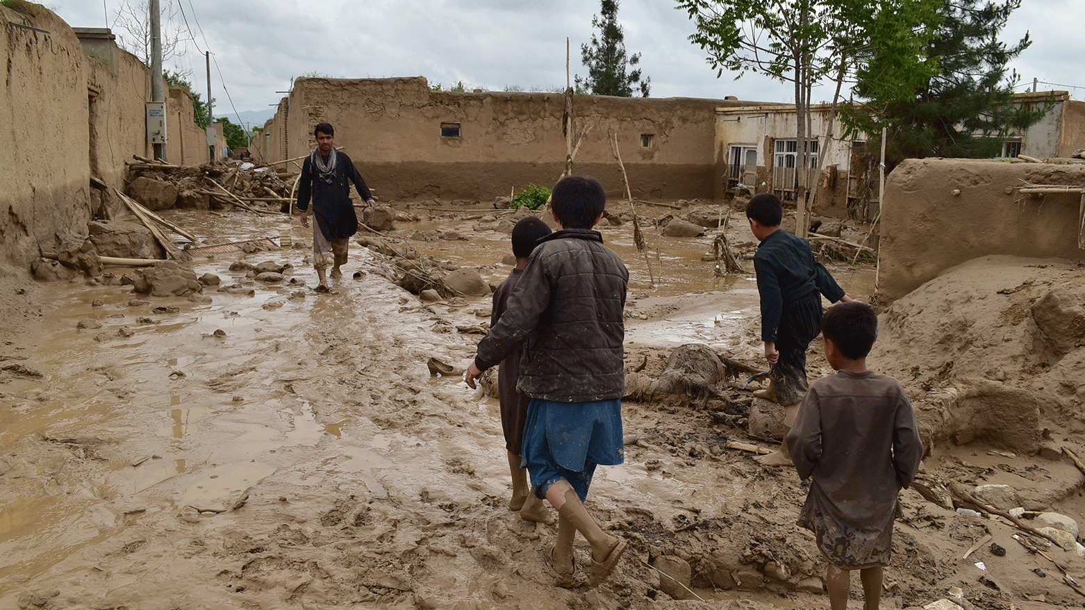 People walk near their damaged homes after heavy flooding in Baghlan province in northern Afghanistan Saturday, May 11, 2024. (Photo: AP)