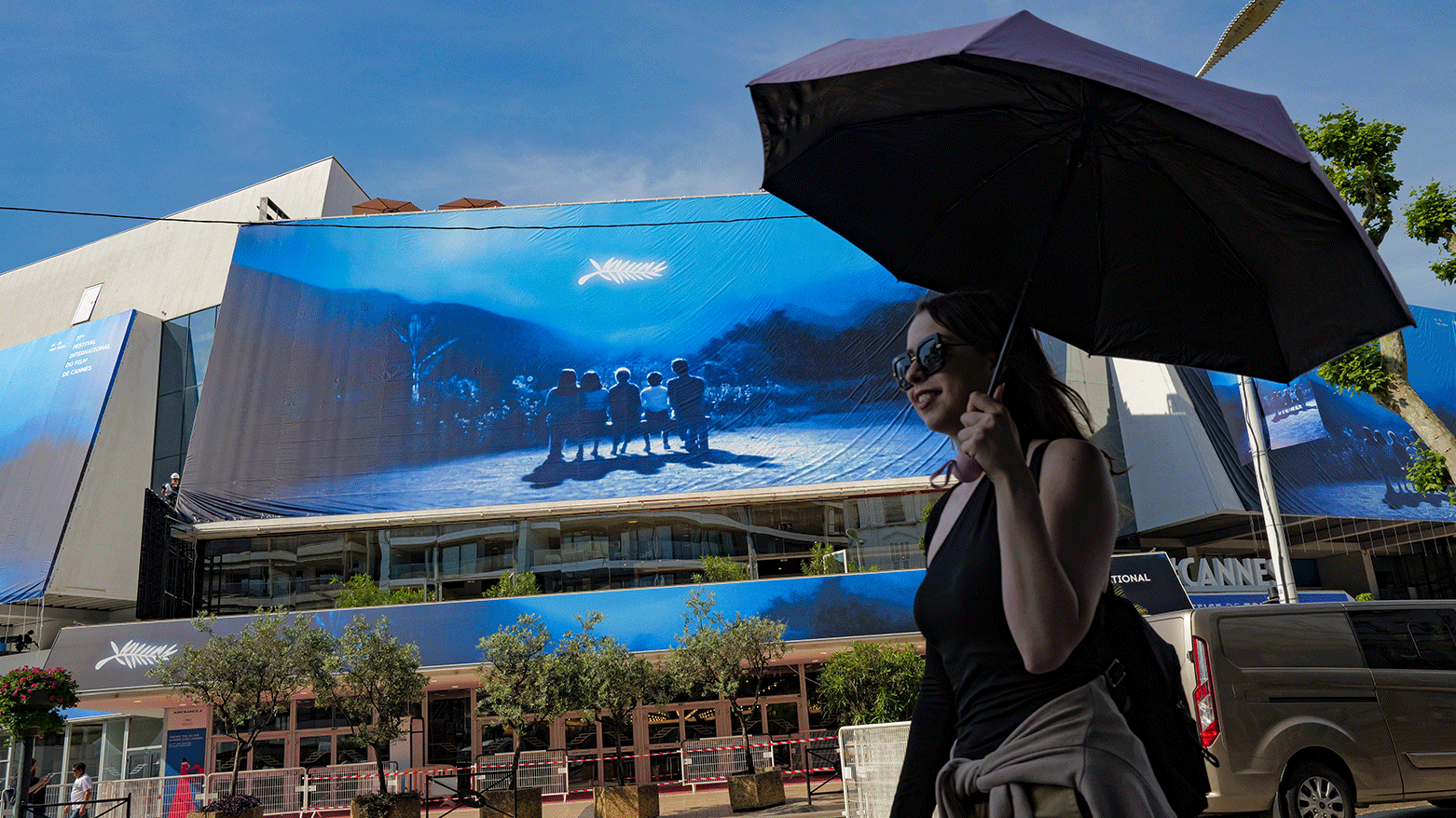 A woman walks in front of the official poster of the 77th Cannes Film Festival on the facade of the Palais des Festivals in Cannes, south-eastern France, on May 12, 2024. (Photo: AFP)