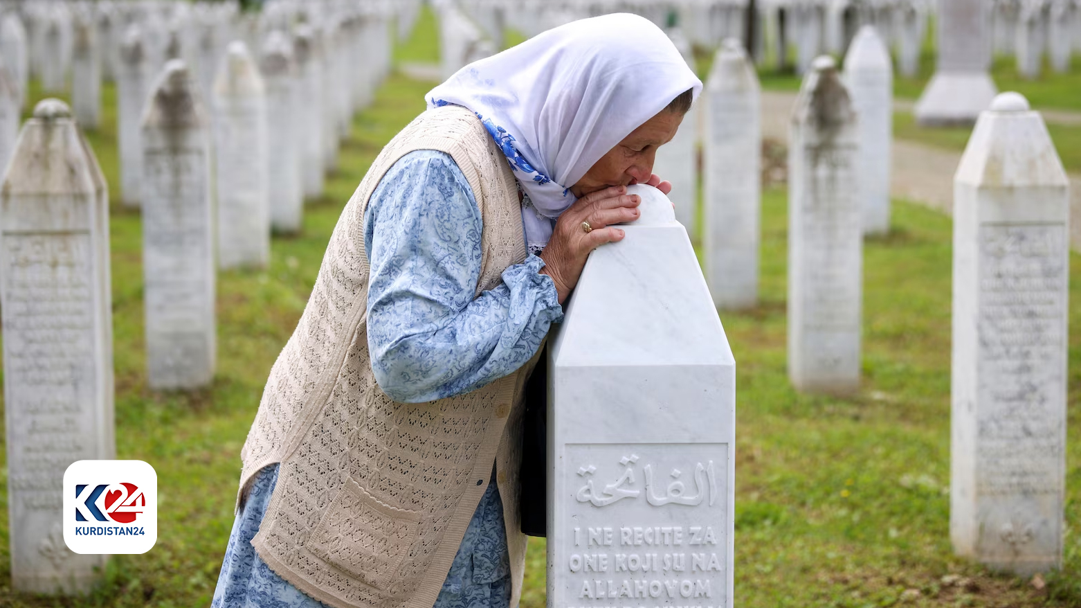 امرأة تُقبّل قبر أحد ضحايا الإبادة