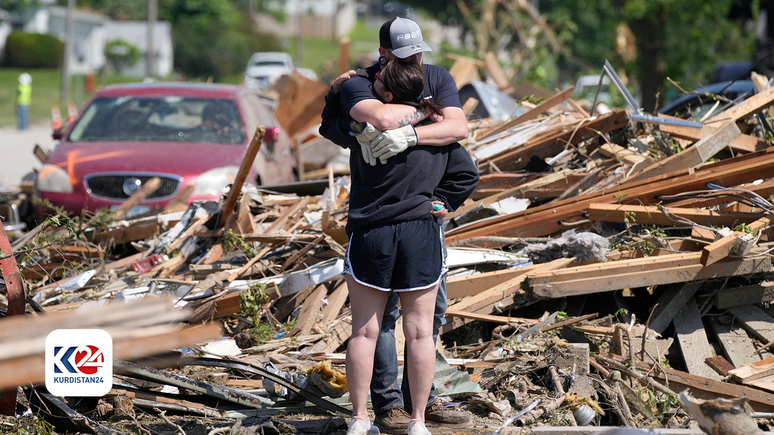 ساکنان محلی در مقابل خانه آسیب دیده طوفان در گرینفیلد آیووا، یکدیگر در آغوش می‌گیرند. چهارشنبه ٢٢ مه ٢٠٢٤