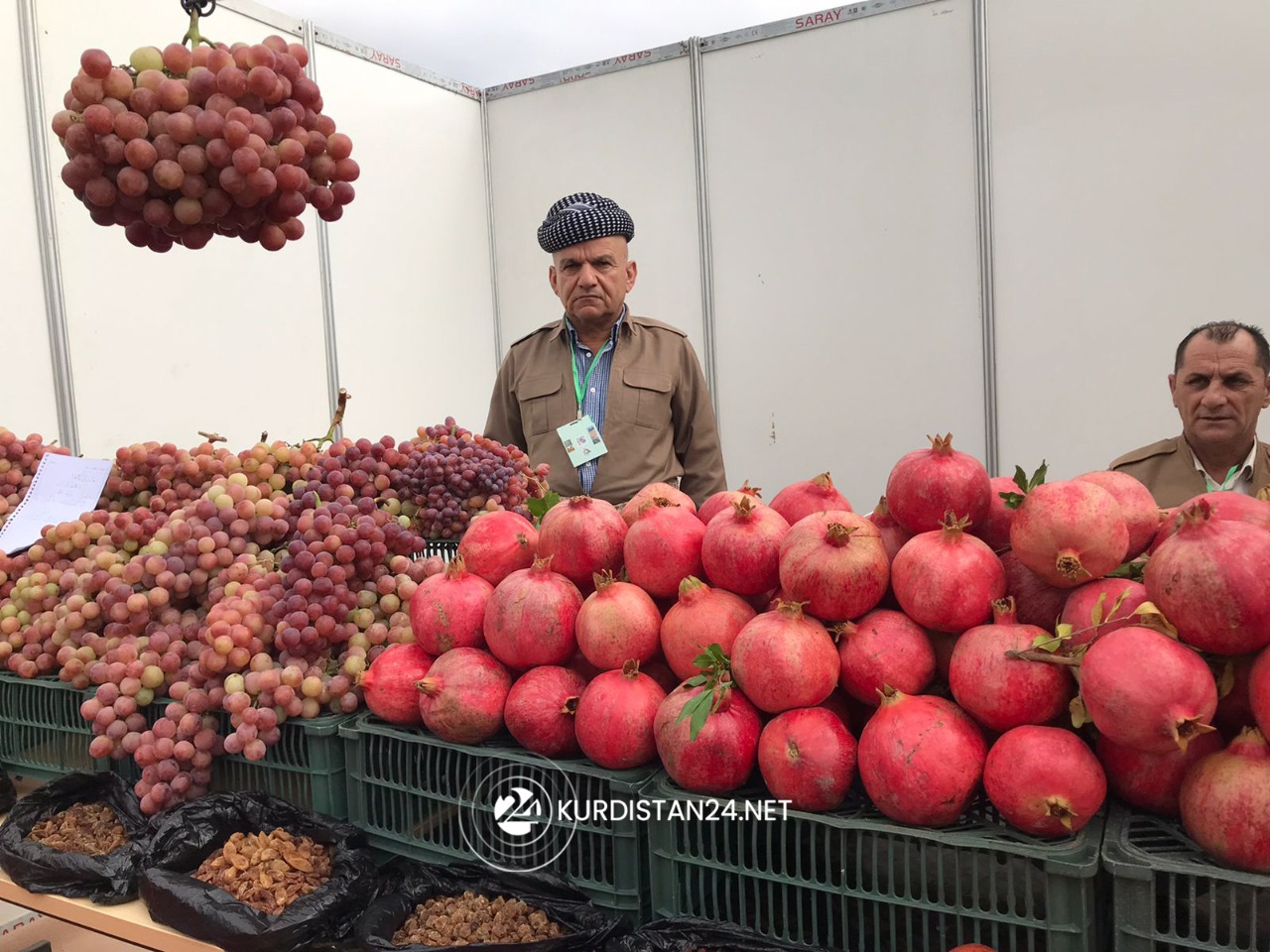 A Kurdish farmer stands at pavilion showcasing locally-produced pomegranates from the Badinan region, Nov. 3, 2021. (Photo: Hero Mawludi/Kurdistan24)