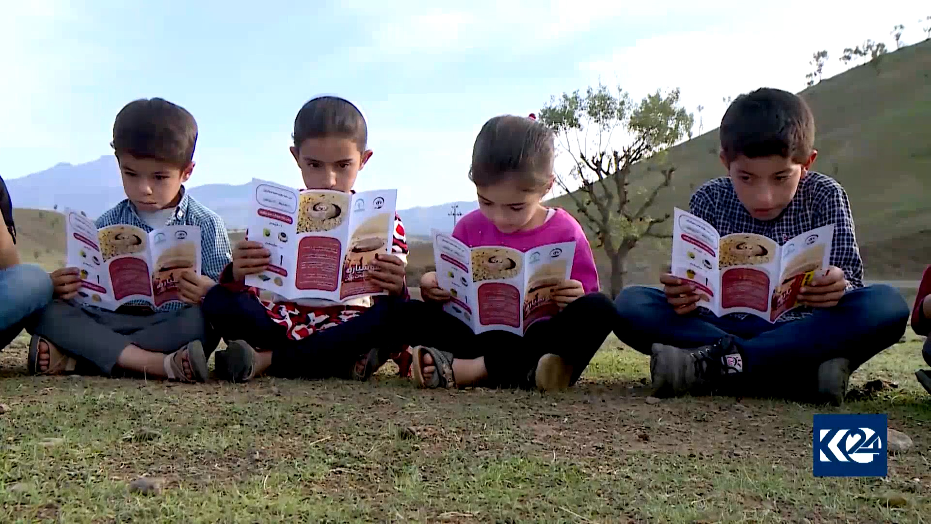 Children are pictured studying leaflets distributed to raise awareness on unexploded landmines and explosives, Nov. 11, 2021. (Photo: Kurdistan 24)