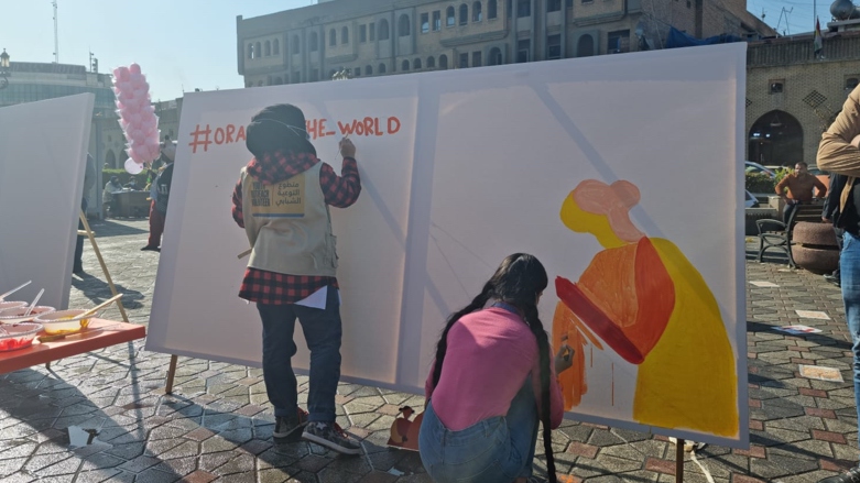 Volunteers paint the hashtag #orange_the_world (Photo: Wladimir van Wilgenburg/Kurdistan 24).
