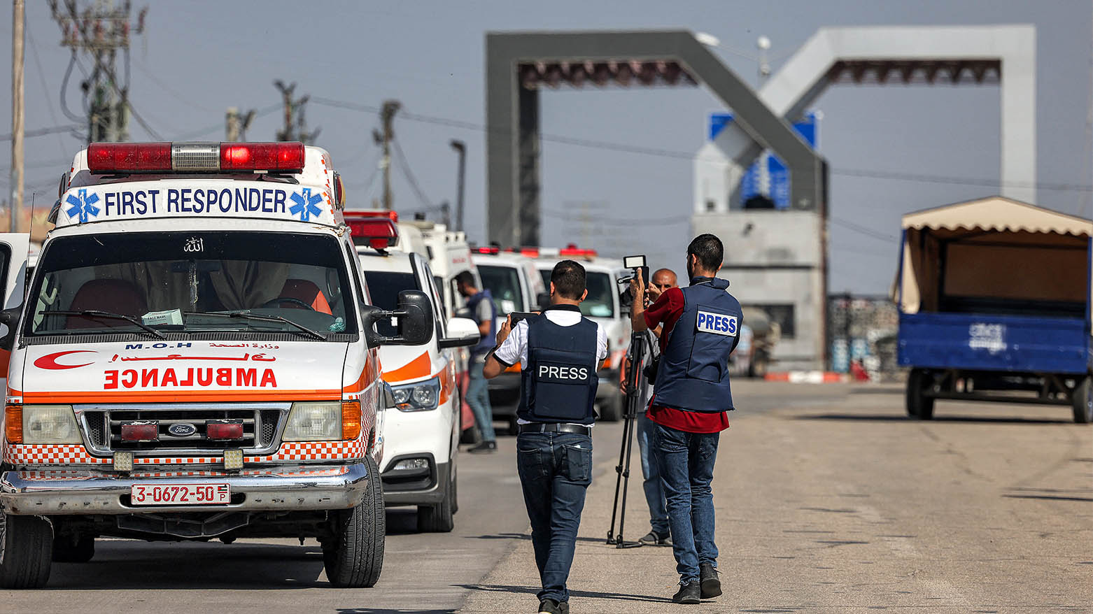 Journalists film as Palestinian health ministry ambulances cross the gate to enter the Rafah border crossing in the southern Gaza Strip before crossing into Egypt on November 1, 2023. (Photo: AFP)