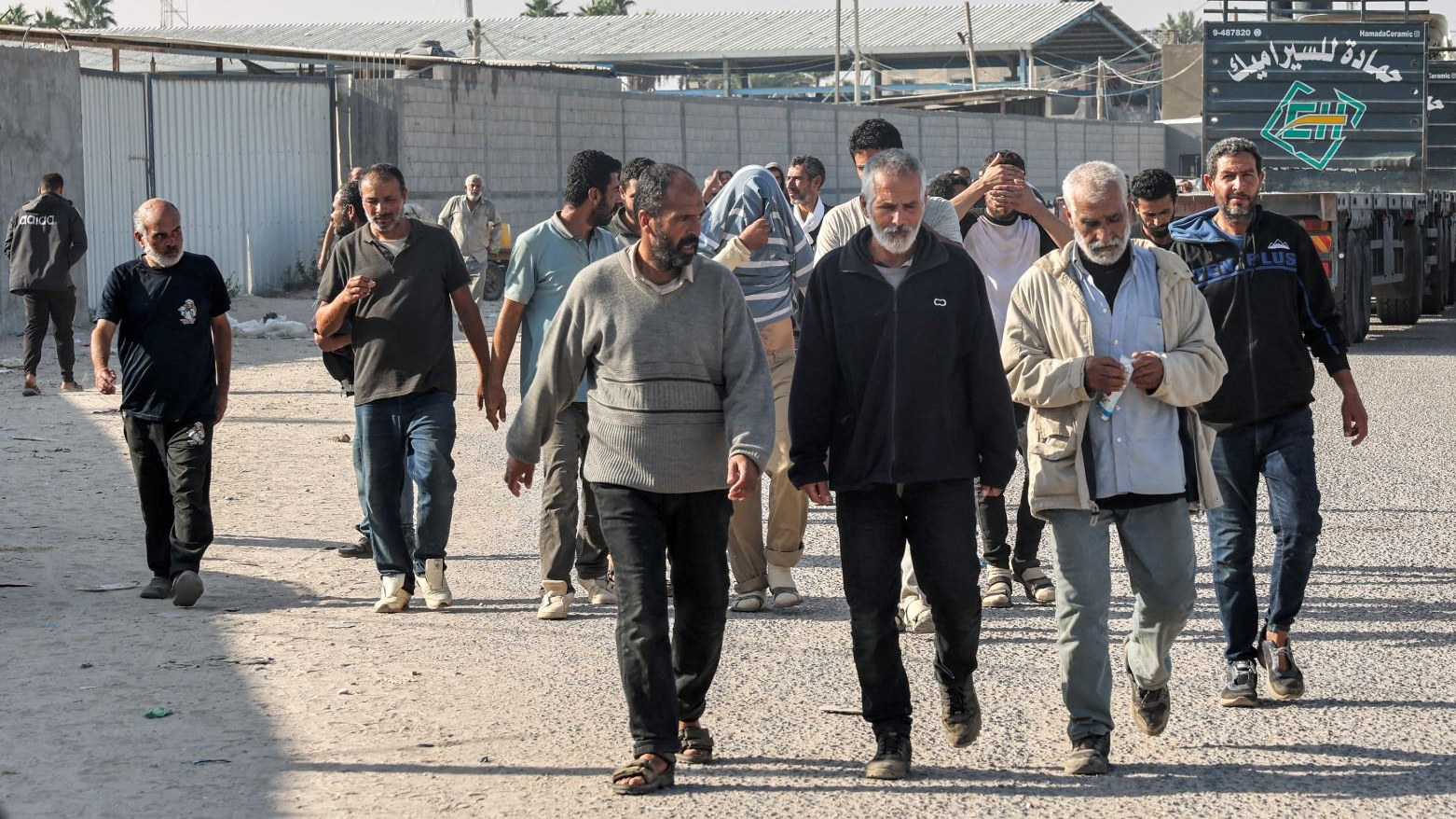 عمالٌ فلسطينيون عائدون إلى قطاع غزة عند معبر كرم أبو سالم الحدودي مع إسرائيل (فرانس برس)