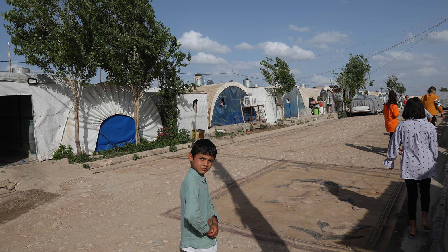 Displaced Yazidis stand by their tents at the Chamishko camp for internally displaced persons in the city of Zakho, northern Iraq, May 5, 2022. (AFP)