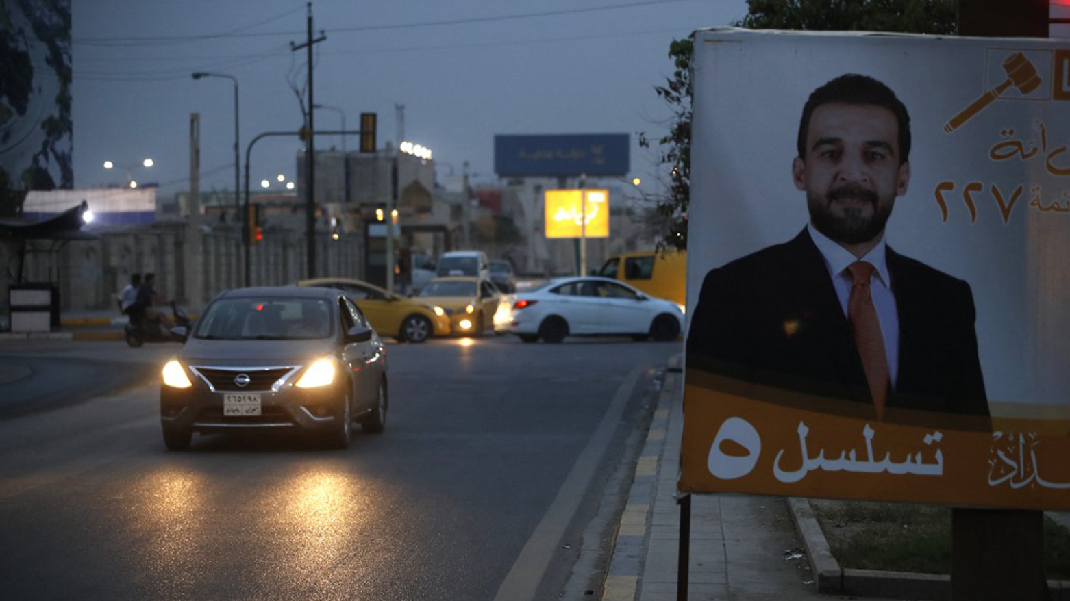 Vehicles drive past a billboard showing Iraqi Parliament Speaker Mohamed al-Halbussi, who is running in the local elections in December, along a main throughfare in Baghdad, Nov. 14, 2023. (Photo: Ahmad Al-Rubaye/AFP)
