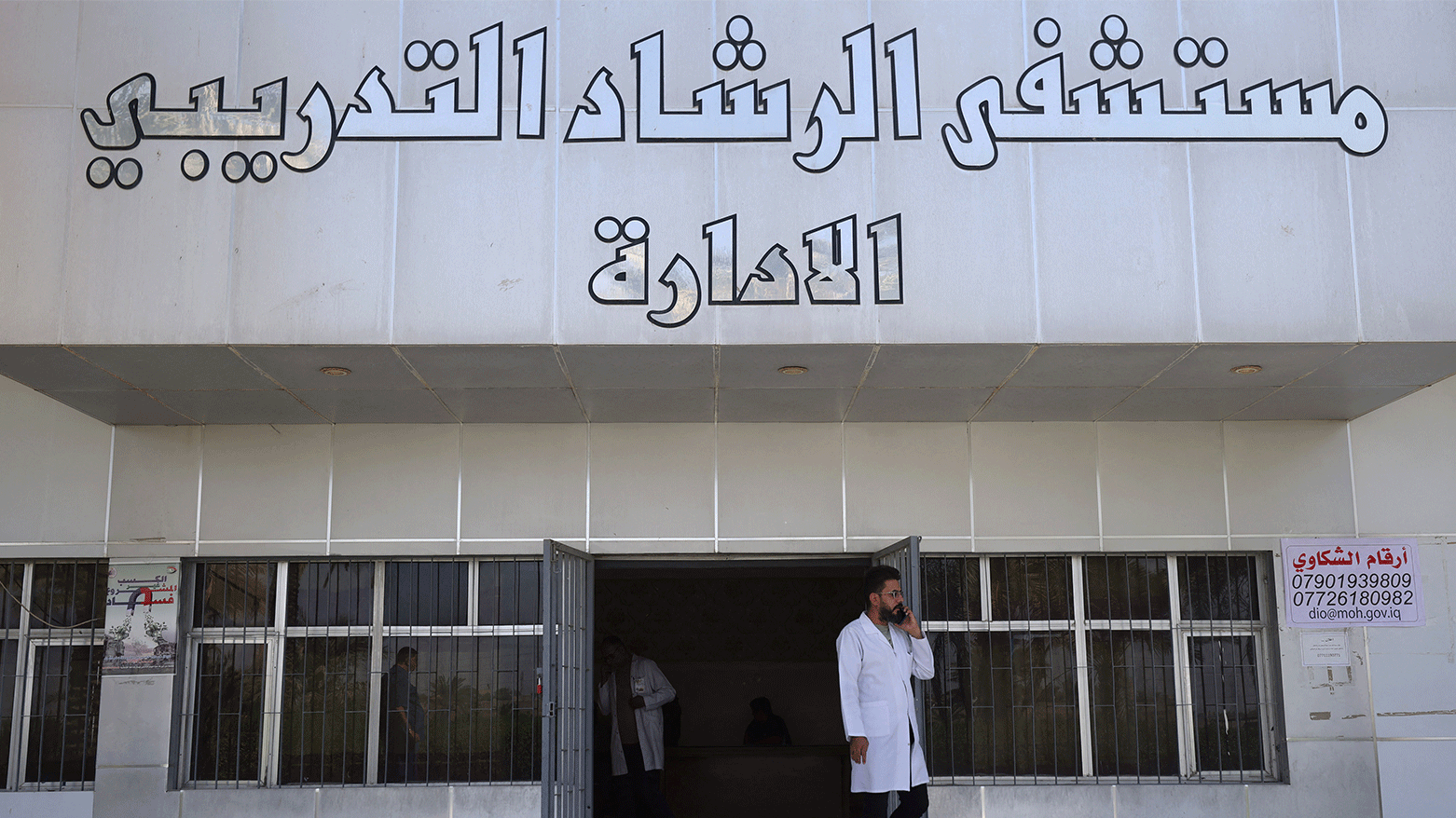 A doctor speaks on the phone outside the administration building of Baghdad's Al-Rashad psychiatric hospital on October 8, 2023. (Photo: AFP)