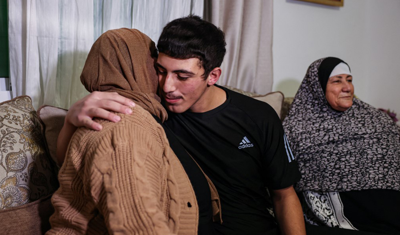 Palestinian Muhammad Abu Al-Humus, hugs his mother upon return to his home in east Jerusalem, on November 28, 2023. (Photo: Ahmed Gharabli/AFP)