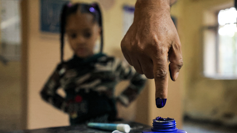 A man dips his finger in ink after voting at a polling station in Iraq's capital Baghdad during the early parliamentary elections, October 10, 2021. (Ahmad al-Rubaye/AFP)
