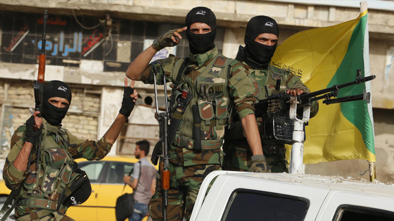 Masked members of Iraq's Shia militia, Kata'ib Hezbollah, holding their weapons as their convoy arrived in Baghdad's Karada neighborhood (Photo: AFP)