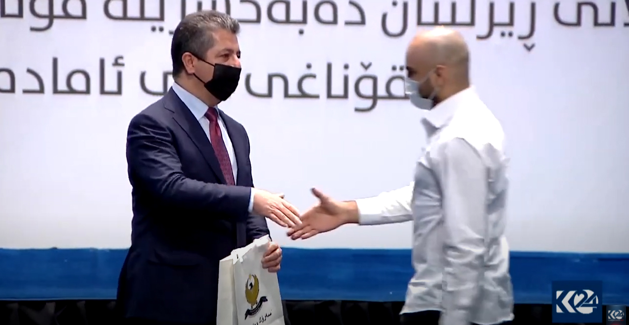 Kurdistan Region PM Masrour Barzani (left) hand shakes with a student at Wednesday's awards ceremony, Oct. 20, 2021. (Photo: KRG)