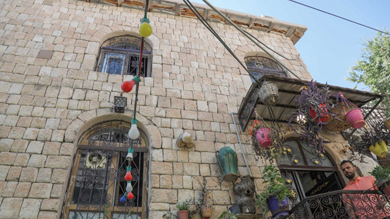 A man stands on the balcony of a stone building in the Kurdish town of Akre, 500 kilometres north of Iraq's capital Baghdad, Sept. 14, 2022. (Photo: Safin Hamed/AFP)