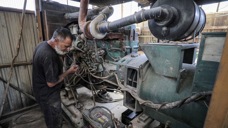 A technician checks the oil on the dipstick of one of the fuel-based electricity generators in a battery in the eastern Sadr City suburb of Iraq's capital Baghdad, Sept. 27, 2022. (Photo: Ahmad Al-Rubaye/AFP)