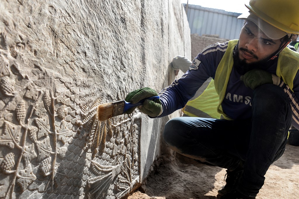 An Iraqi worker excavates a rock-carving relief recently found at the Mashki Gate in northern Iraqi city of Mosul, Oct. 19, 2022. (Photo: Zaid al-Obeidi/AFP)