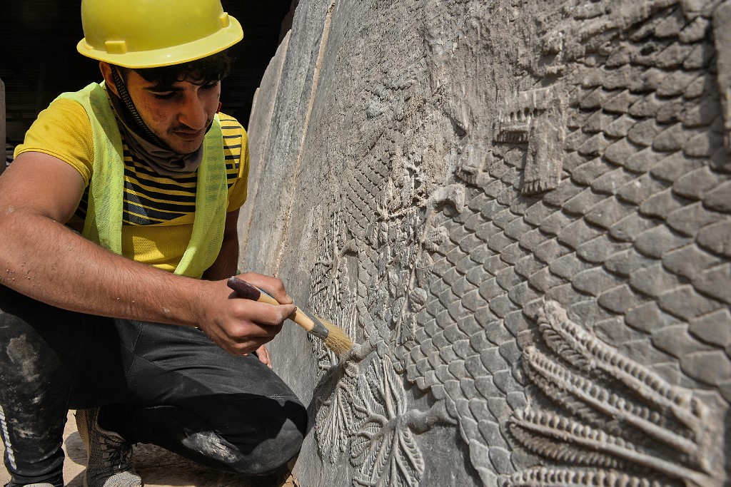 An Iraqi worker excavates a rock-carving relief recently found at the Mashki Gate in northern Iraqi city of Mosul, Oct. 19, 2022. (Photo: Zaid al-Obeidi/AFP)