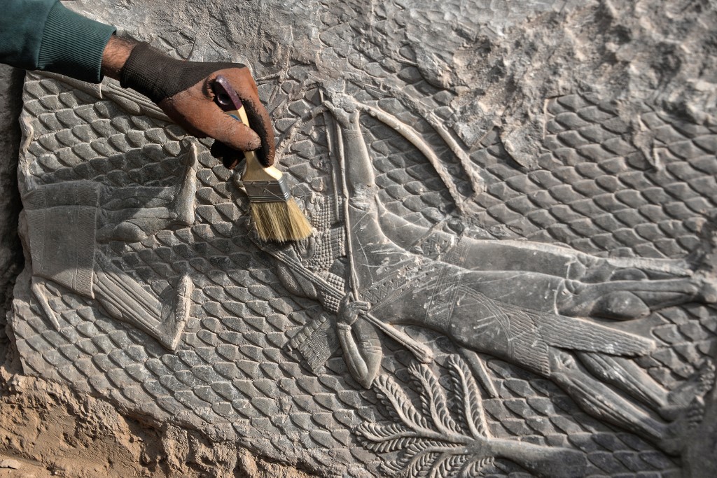 An Iraqi worker excavates a rock-carving relief recently found at the Mashki Gate in northern Iraqi city of Mosul, Oct. 19, 2022. (Photo: Zaid al-Obeidi/AFP)