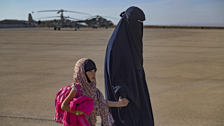 A woman accompanies a child toward a plane before being repatriated to Russia, at the airport of the city of Qamishli in Syria's northeastern Hasakeh province, Oct. 20, 2022. (Photo: Delil Souleiman/AFP)