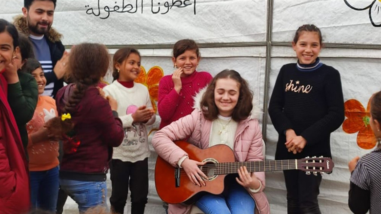 Sirin Mazlum is playing music for the children of a refugee camp