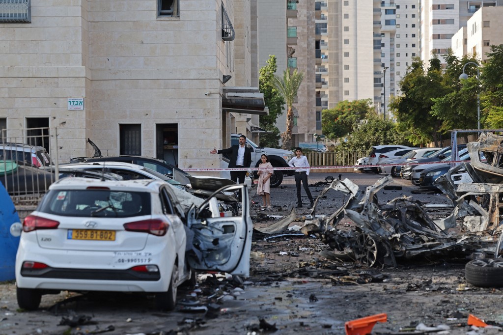 Residents walk past burnt-out vehicles in Ashkelon following a rocket attack from the Gaza Strip into Israel, October 7, 2023.  (Photo: Ahmad Gharabli/AFP)