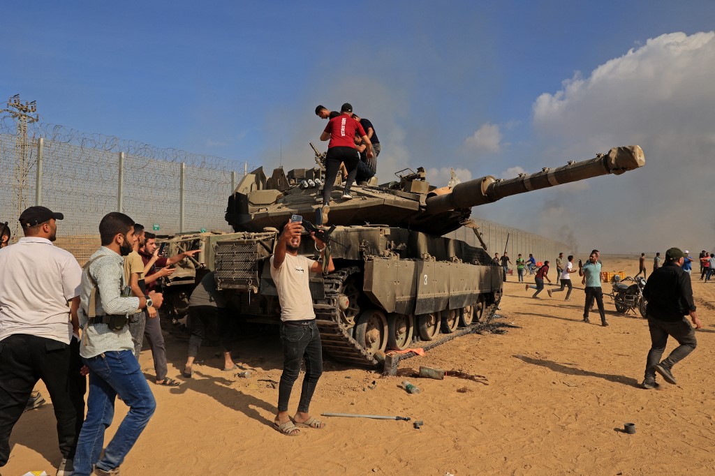 Palestinians take control of an Israeli tank after crossing the border fence with Israel from Khan Yunis in the southern Gaza Strip, October 7, 2023. (Photo: Said Khatib/AFP)