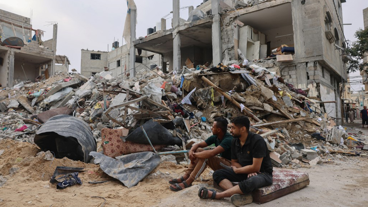 Two young Palestinians sit in front of a levelled building following overnight Israeli air strikes on Rafah in the southern Gaza Strip, Oct. 9, 2023. (Photo: Said Khatib/AFP)