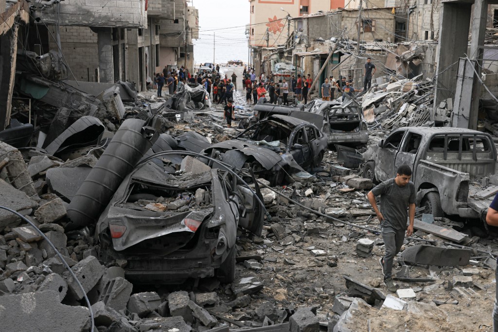 Palestinians inspect the destruction in a neighbourhood heavily damaged by Israeli airstrikes on Gaza City's Shati refugee camp early, Oct. 9, 2023. (Photo: Mahmud Hams/AFP)