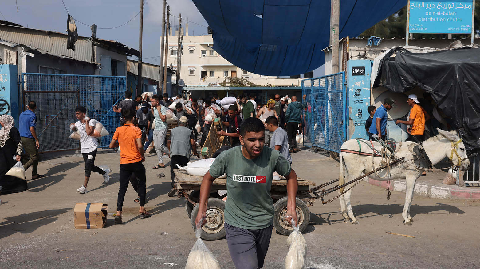 Palestinians storm a UN-run aid supply center, that distributes food to displaced families, in Deir al-Balah on October 28, 2023. (Photo: Mohammed Abed/ AFP)