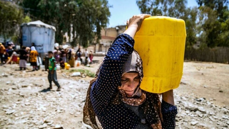 سيدة تحمل على كتفها عبوة ماء في 8 تموز/يوليو 2021 في مدينة الحسكة في شمال شرق سوريا والتي تشهد انقطاعا متكررا للمياه  - الصورة لفرانس 24
