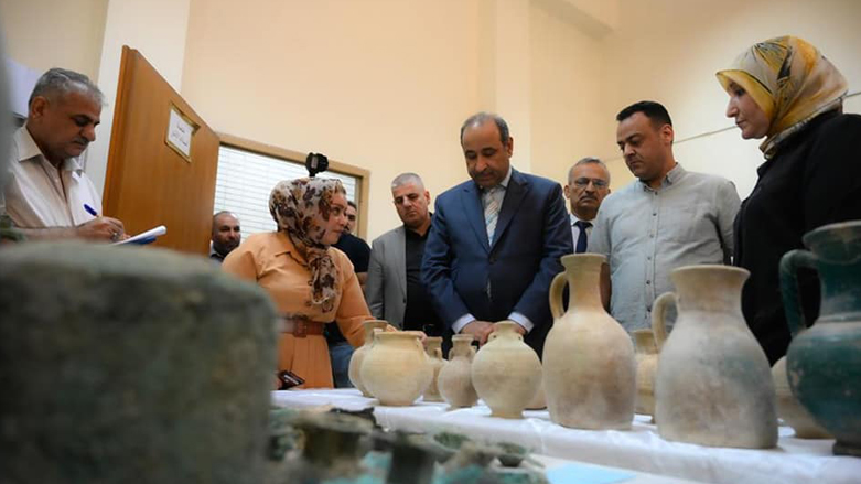 Iraqi officials review a number of artifacts. (Photo: Ministry of Culture, Tourism and Antiquities)