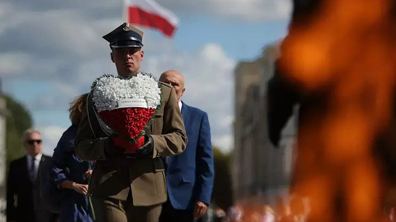 A Polish soldier holding a wreath of flowers during the national observance of WWII anniversary in Warsaw, Sept. 1, 2022. (Photo: AP)