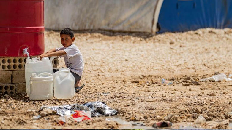 A displaced Syrian boy from Ras al-Ain, a border town controlled by Turkey and its Syrian proxies, fills jerry cans with water at the Washukanni camp in Syria's northeastern Hasakeh province on April 16, 2020 (Photo: DELIL SOULEIMAN/AFP).