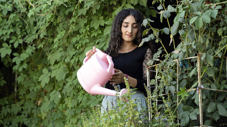 Khalida Shamo , 28, waters her flowers at a Duhok camp. (Photo: Anadolu Agency)