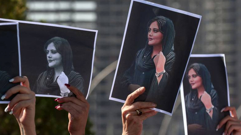Demonstrators hold up images of Amini (Photo: AFP).