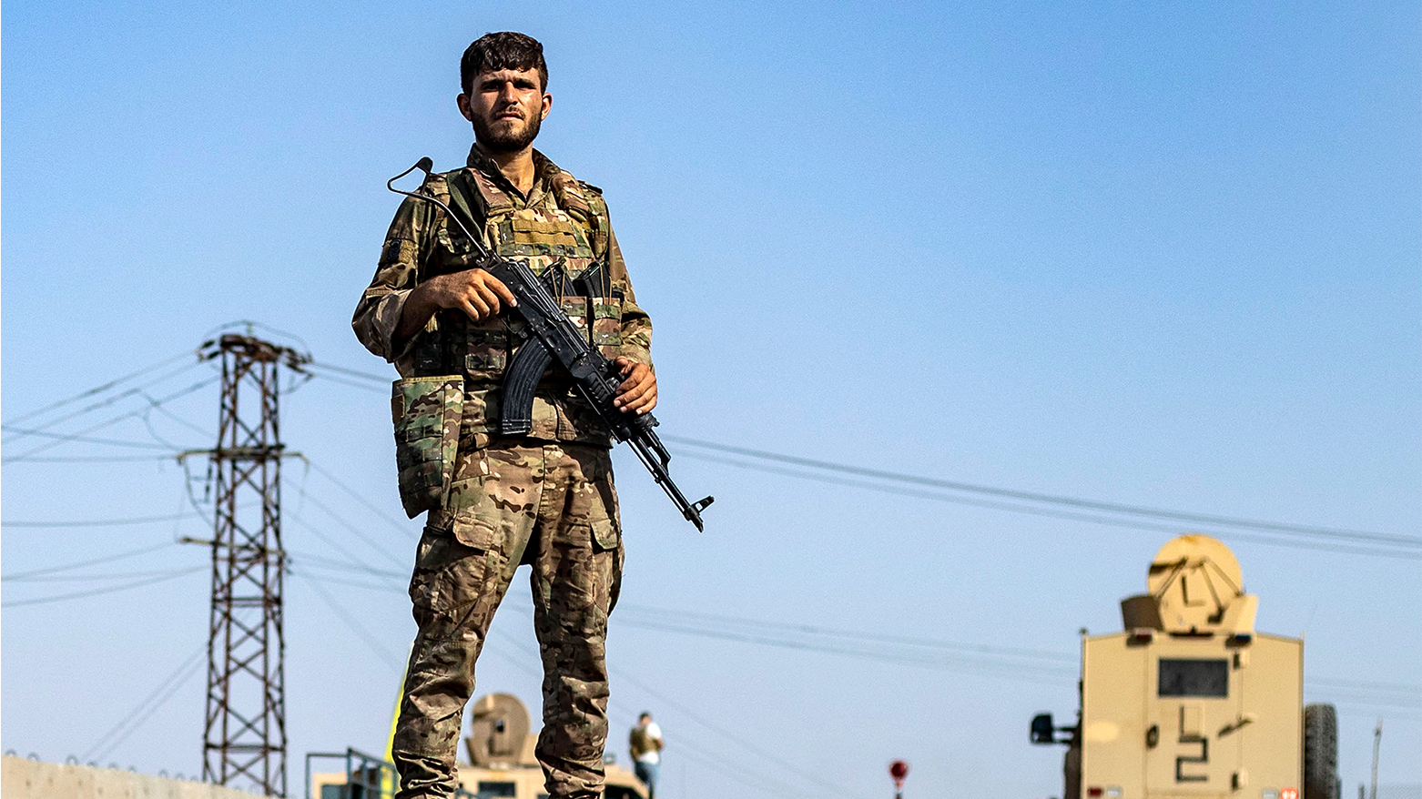 A fighter of the Syrian Democratic Forces (SDF) stands guard along a road as others deploy to impose a curfew in the town of al-Busayrah in Syria's northeastern Deir Ezzor province on Sept. 4, 2023. (Photo: Delil Souleiman/ AFP)