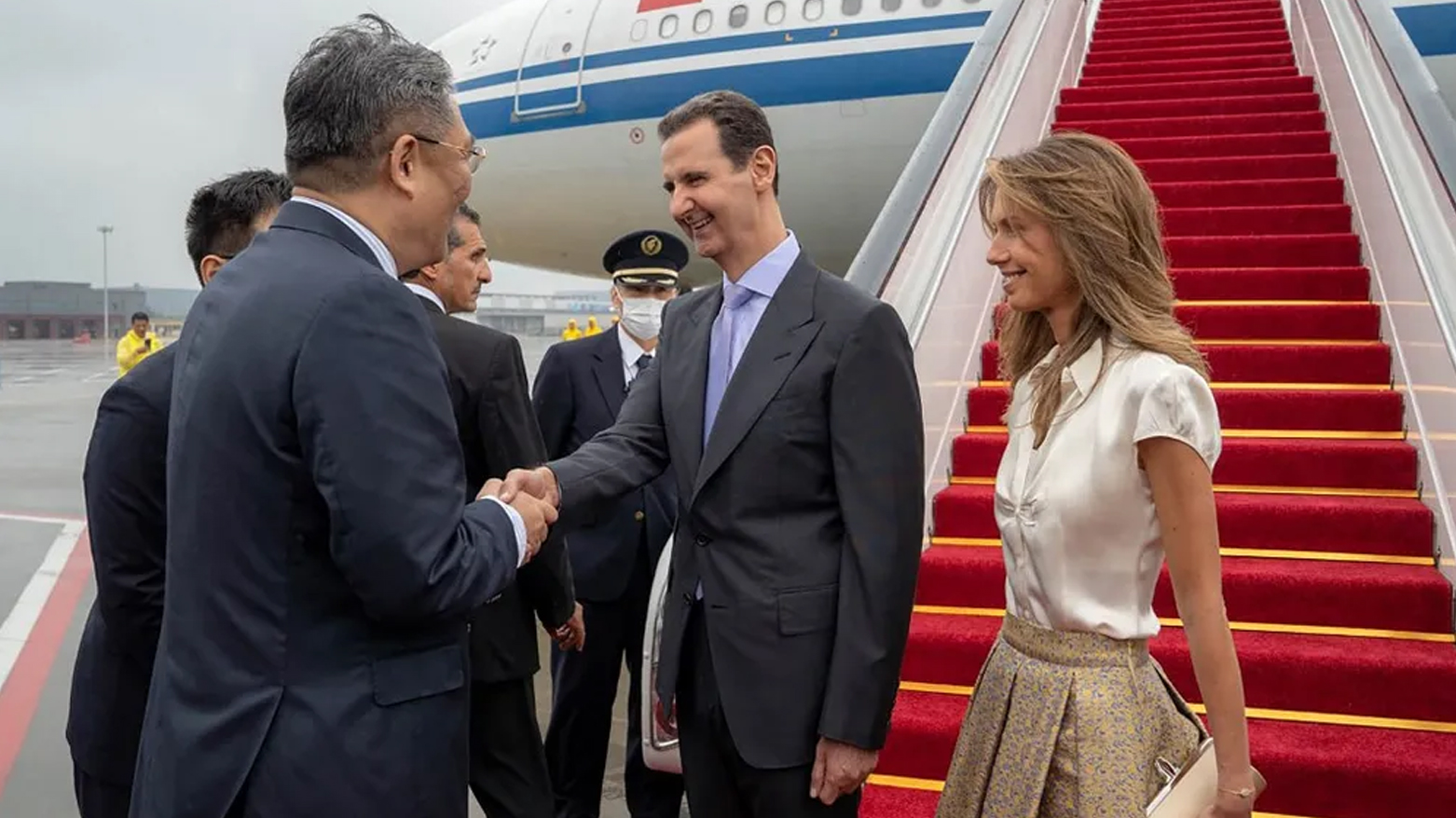 أثناء استقبال الرئيس السوري وزوجته لدى وصولهما إلى مطار بكين (سانا)