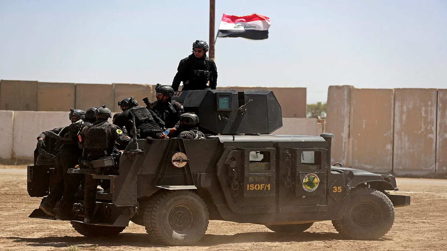 عربة عسكرية ترفع العلم العراقي (فرانس برس)